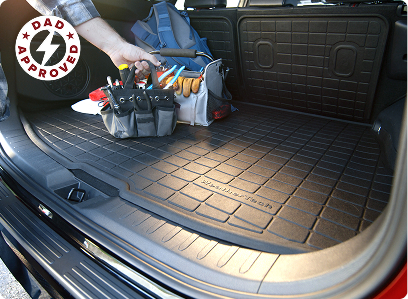 trunk of car with a amige liner and tool box sitting on top