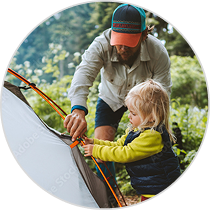 man and son setting up camping tent