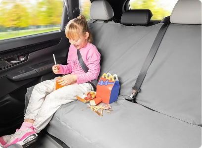 child eating fast food in back of vehicle with seat protector installed
